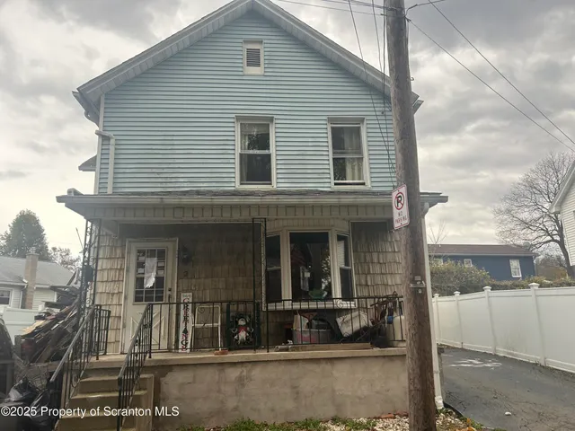 a view of a house with a small yard and wooden floor and fence