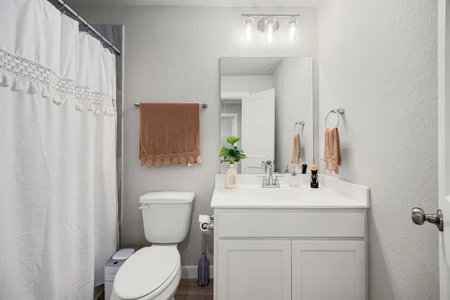 a bathroom with a toilet sink and mirror