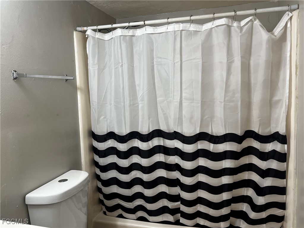 824 Alderman Street, Unit 106 Fort Myers, FL 33916 - Photo 6 of 6 a bathroom with a toilet and a shower curtain