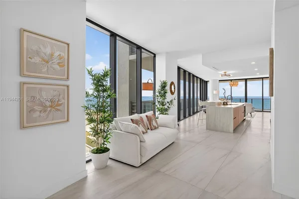 a living room with furniture a flat screen tv and a large window