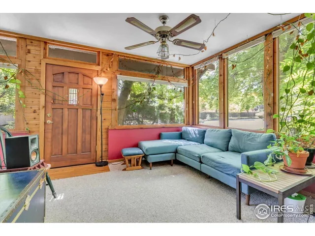 a living room with furniture a flat screen tv and a large window