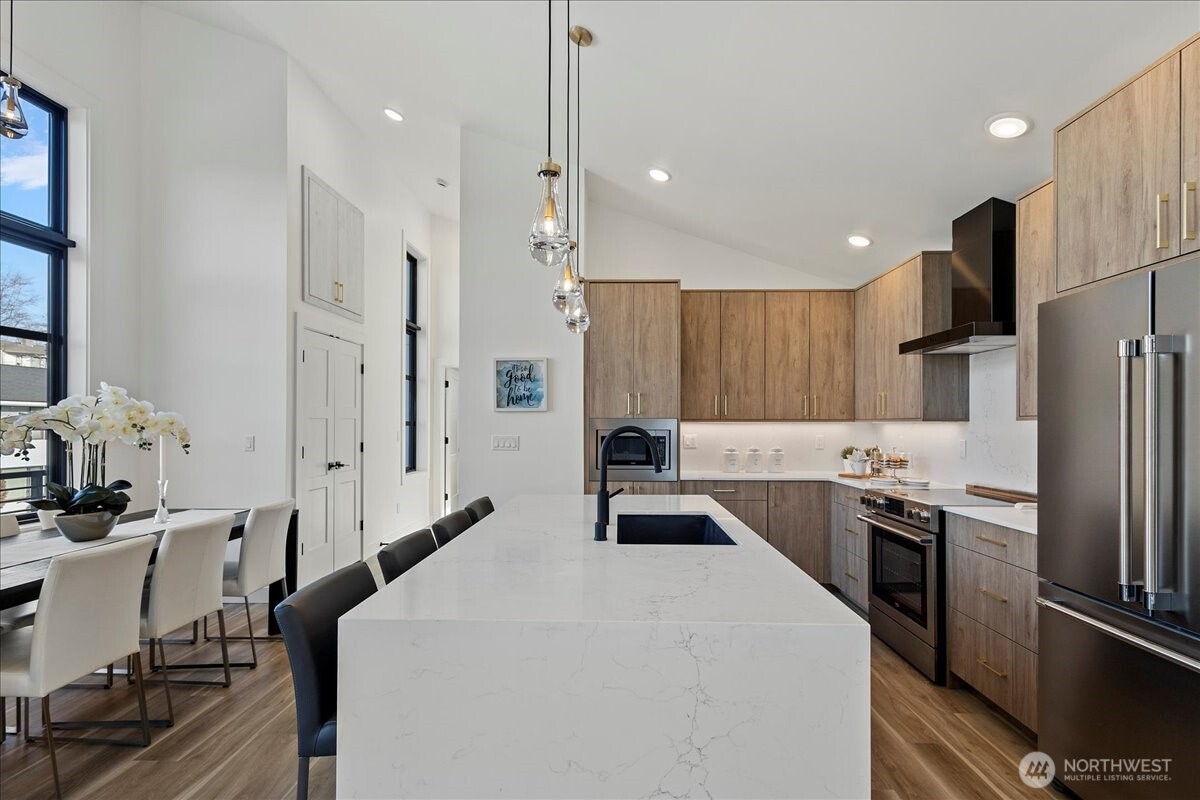 208 Skipping Stone Loop Lynden, WA 98264 - Photo 8 of 28 a kitchen with stainless steel appliances a refrigerator a stove a sink a dining table and chairs