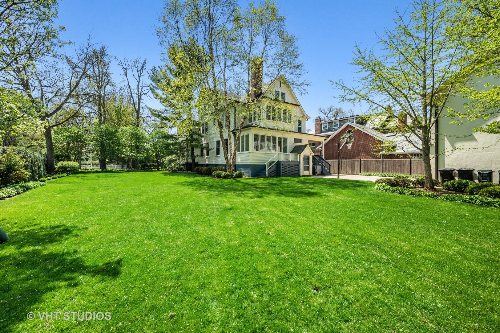 615 Elm Street Winnetka, IL 60093 - Photo 4 of 43 a view of a white house with a big yard and large trees