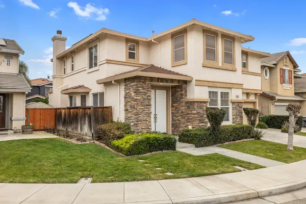 a view of a white house with a yard and plants