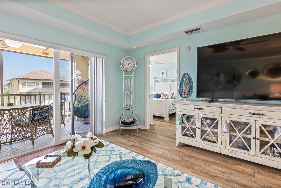 1799 Four Mile Cove Parkway, Unit 925 Cape Coral, FL 33990 - Photo 17 of 49 a living room with furniture a flat screen tv and floor to ceiling window