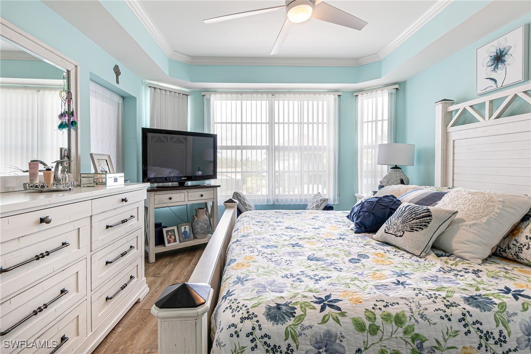 1799 Four Mile Cove Parkway, Unit 925 Cape Coral, FL 33990 - Photo 27 of 49 a bedroom with a bed and a flat tv screen on dresser
