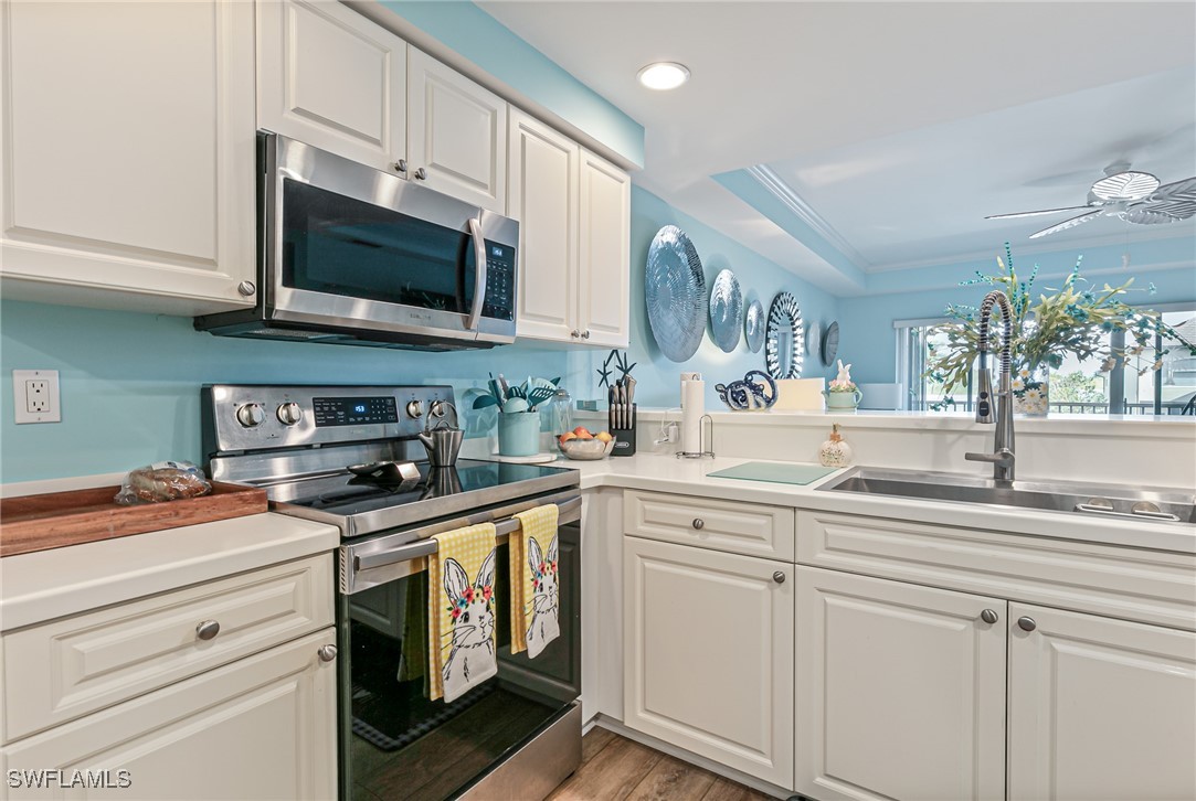 1799 Four Mile Cove Parkway, Unit 925 Cape Coral, FL 33990 - Photo 5 of 49 a kitchen with stainless steel appliances granite countertop white cabinets a sink and dishwasher