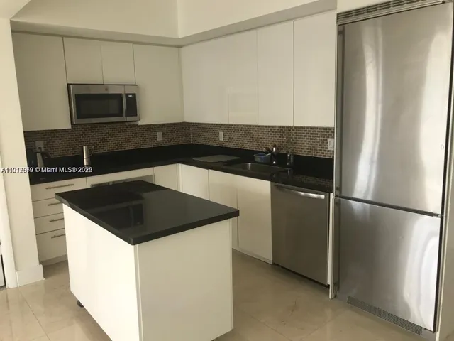 a kitchen with a refrigerator and a sink