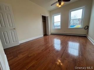 390 Main Street, Unit 3 Beacon, NY 12508 - Photo 4 of 8 Unfurnished bedroom with a baseboard radiator, ceiling fan, baseboards, and wood finished floors