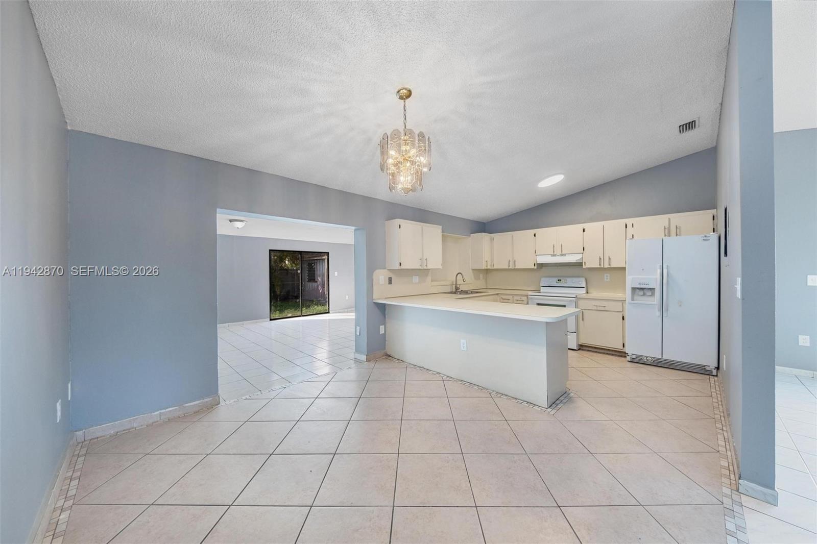 2348 Southwest 138th Place Miami, FL 33175 - Photo 12 of 35 a large white kitchen with a stove a sink dishwasher and a refrigerator with white cabinets