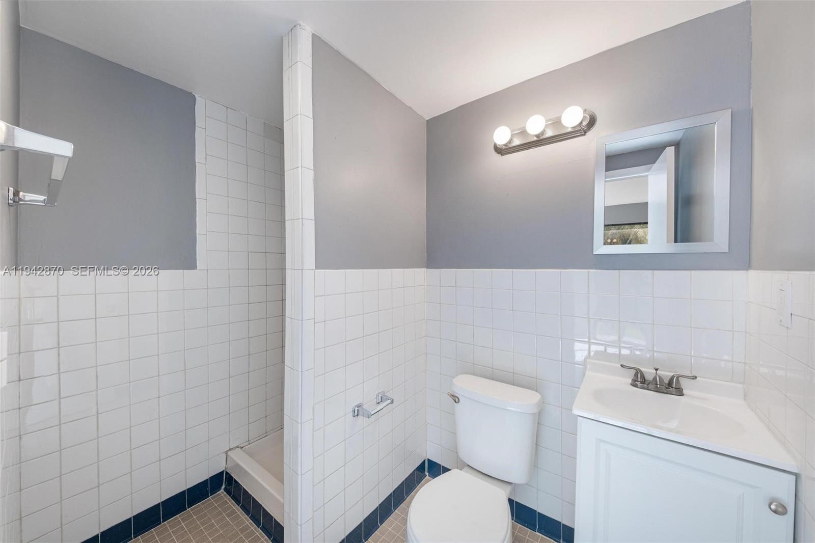 2348 Southwest 138th Place Miami, FL 33175 - Photo 23 of 35 a bathroom with a toilet a sink and mirror