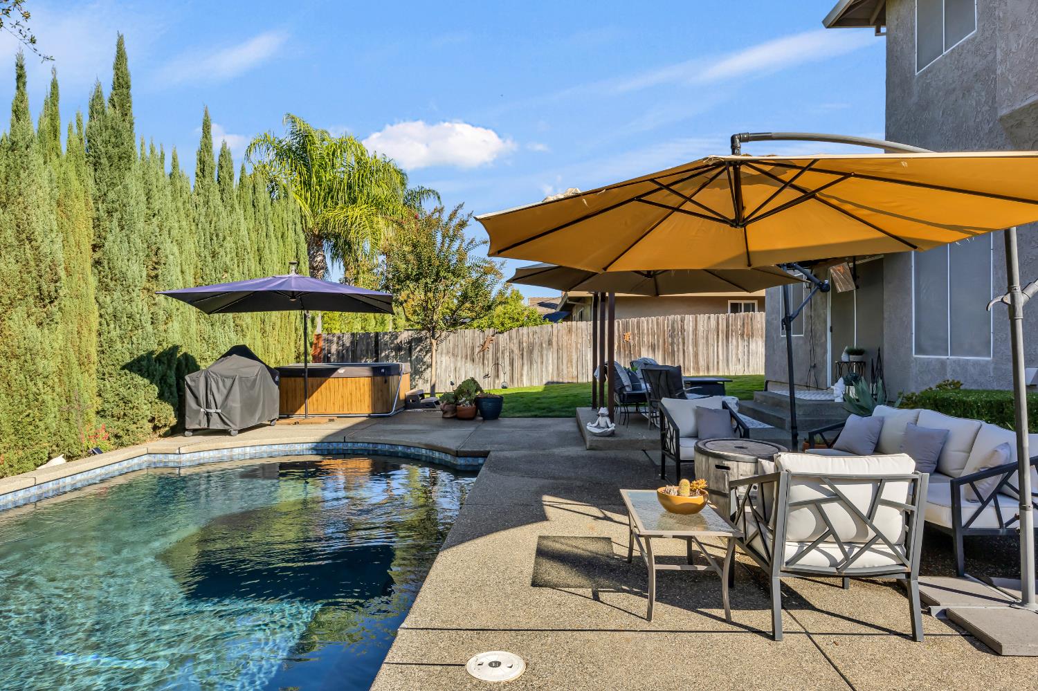 6113 Kifisia Way Fair Oaks, CA 95628 - Photo 44 of 67 a patio with a table and chairs under an umbrella