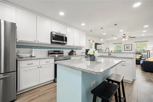 a bathroom with a granite countertop sink a toilet and shower