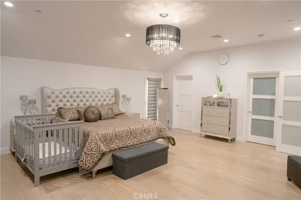 a bedroom with a bed and wooden floor