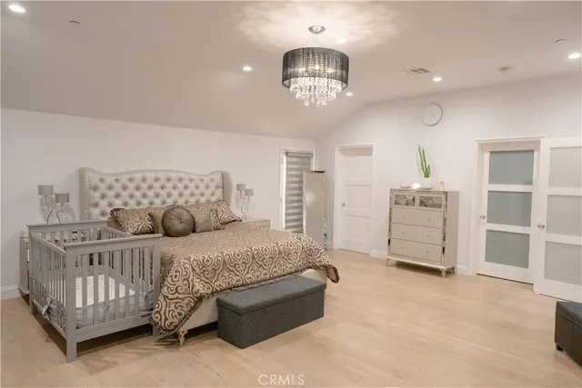 a bedroom with a bed and wooden floor