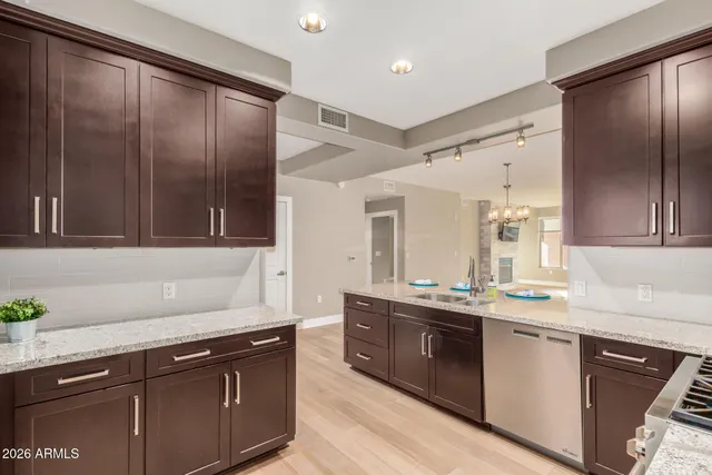 a kitchen with stainless steel appliances granite countertop a sink stove and cabinets