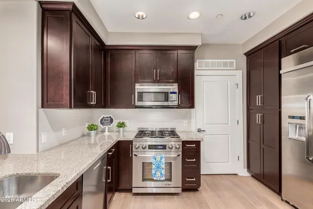 a kitchen with stainless steel appliances granite countertop a stove and a sink