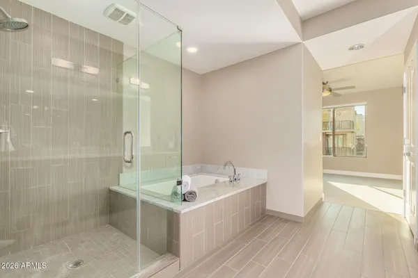 a bathroom with a bathtub a sink a mirror and a shower