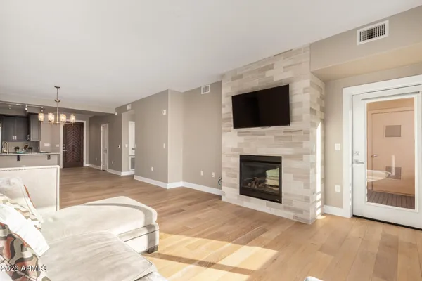 a view of a livingroom with a fireplace a flat screen tv and staircase