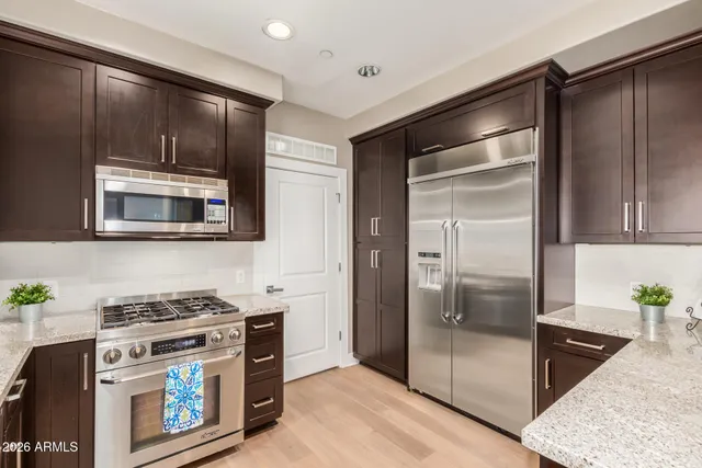 a kitchen with stainless steel appliances granite countertop a refrigerator and a stove