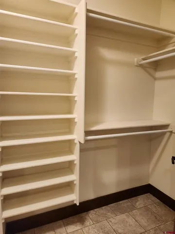 a view of walk in closet with empty racks