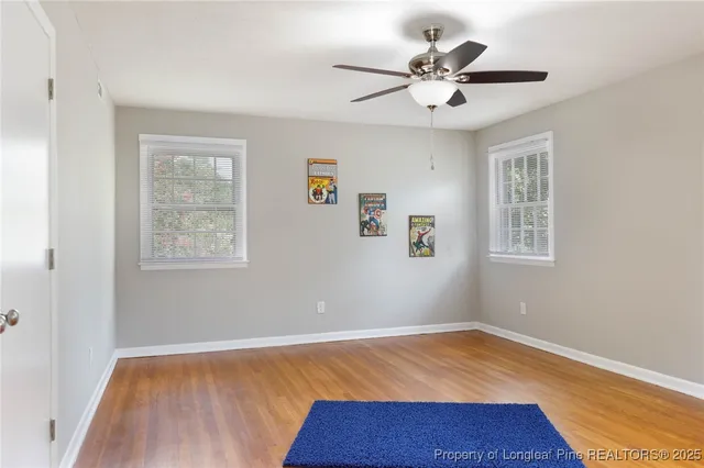 an empty room with a window and ceiling fan