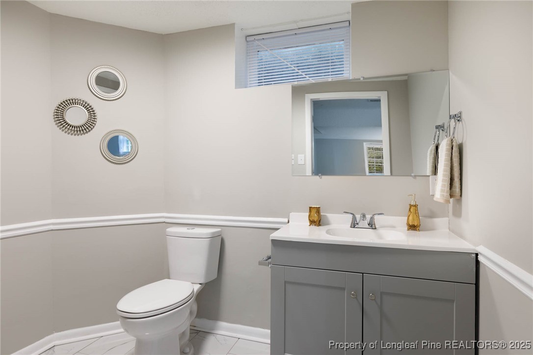 2419 Morganton Road Fayetteville, NC 28303 - Photo 39 of 44 a bathroom with a toilet sink vanity and mirror