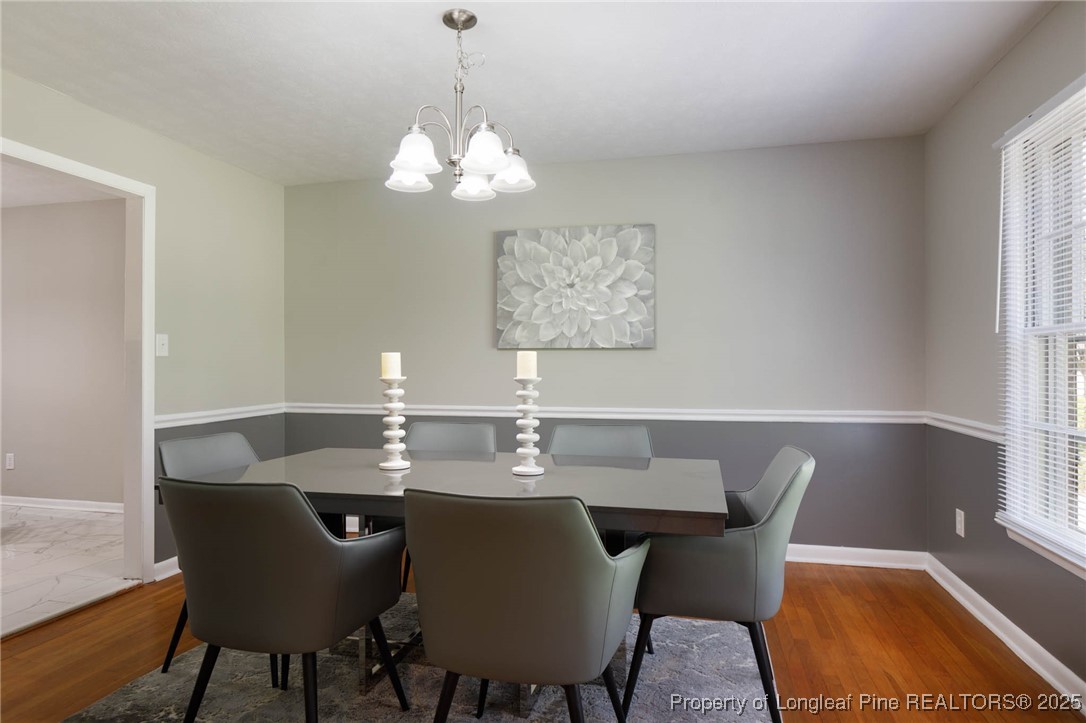 2419 Morganton Road Fayetteville, NC 28303 - Photo 7 of 44 a view of a dining room with furniture a chandelier and wooden floor