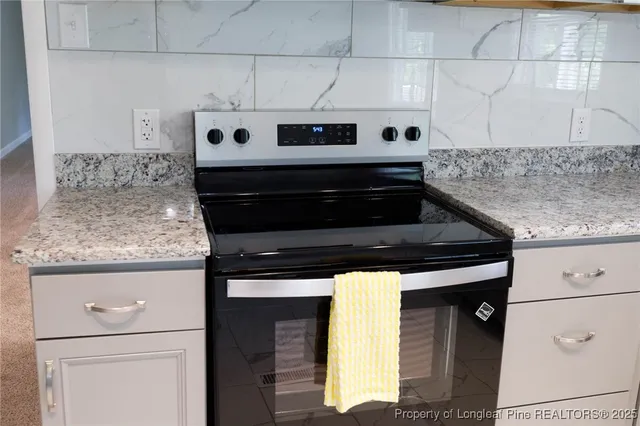 a kitchen with granite countertop cabinets and stove top oven