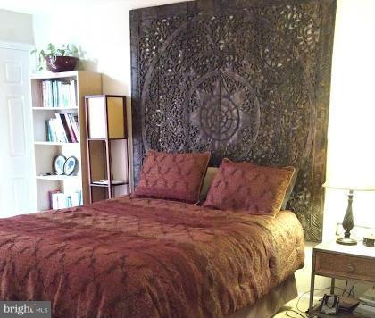 11286 Harbor Court, Unit 11286 Reston, VA 20191 - Photo 26 of 27 a large bed sitting in a bedroom next to a lamp