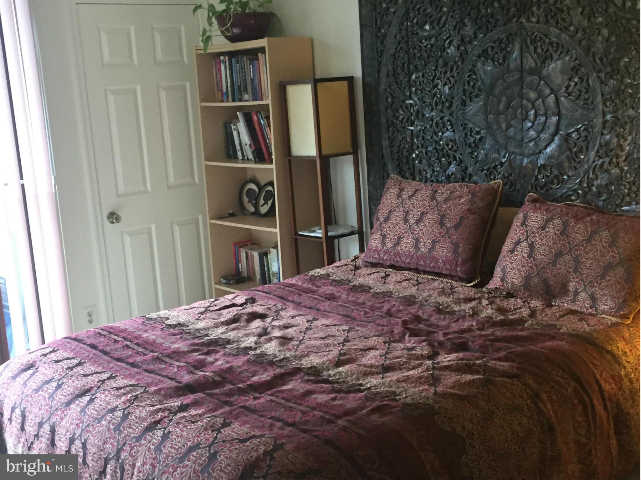 11286 Harbor Court, Unit 11286 Reston, VA 20191 - Photo 4 of 27 a bed sitting in a bedroom and a book shelf