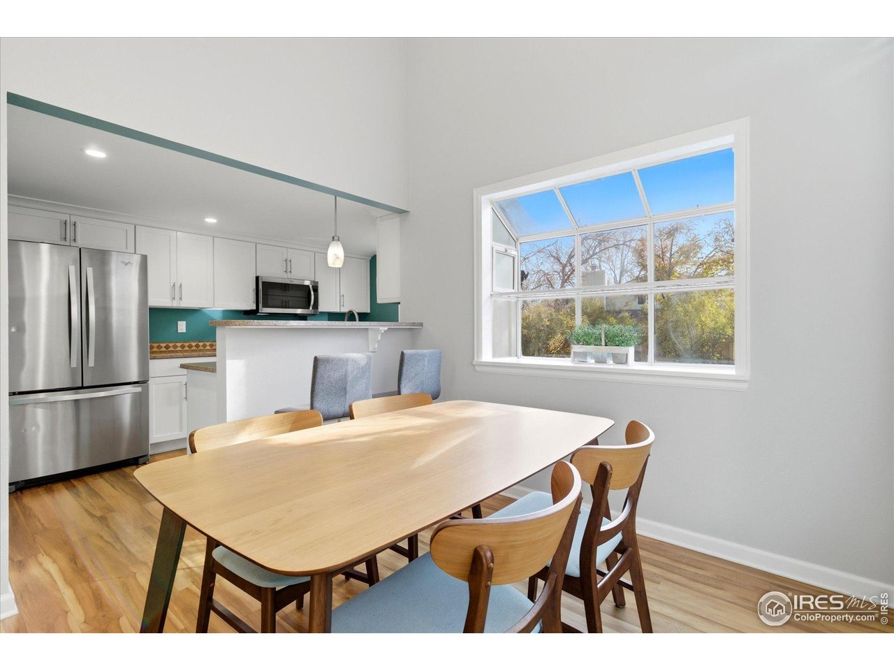 1812 Rice Street Longmont, CO 80501 - Photo 13 of 44 a kitchen with a table chairs a refrigerator and a window