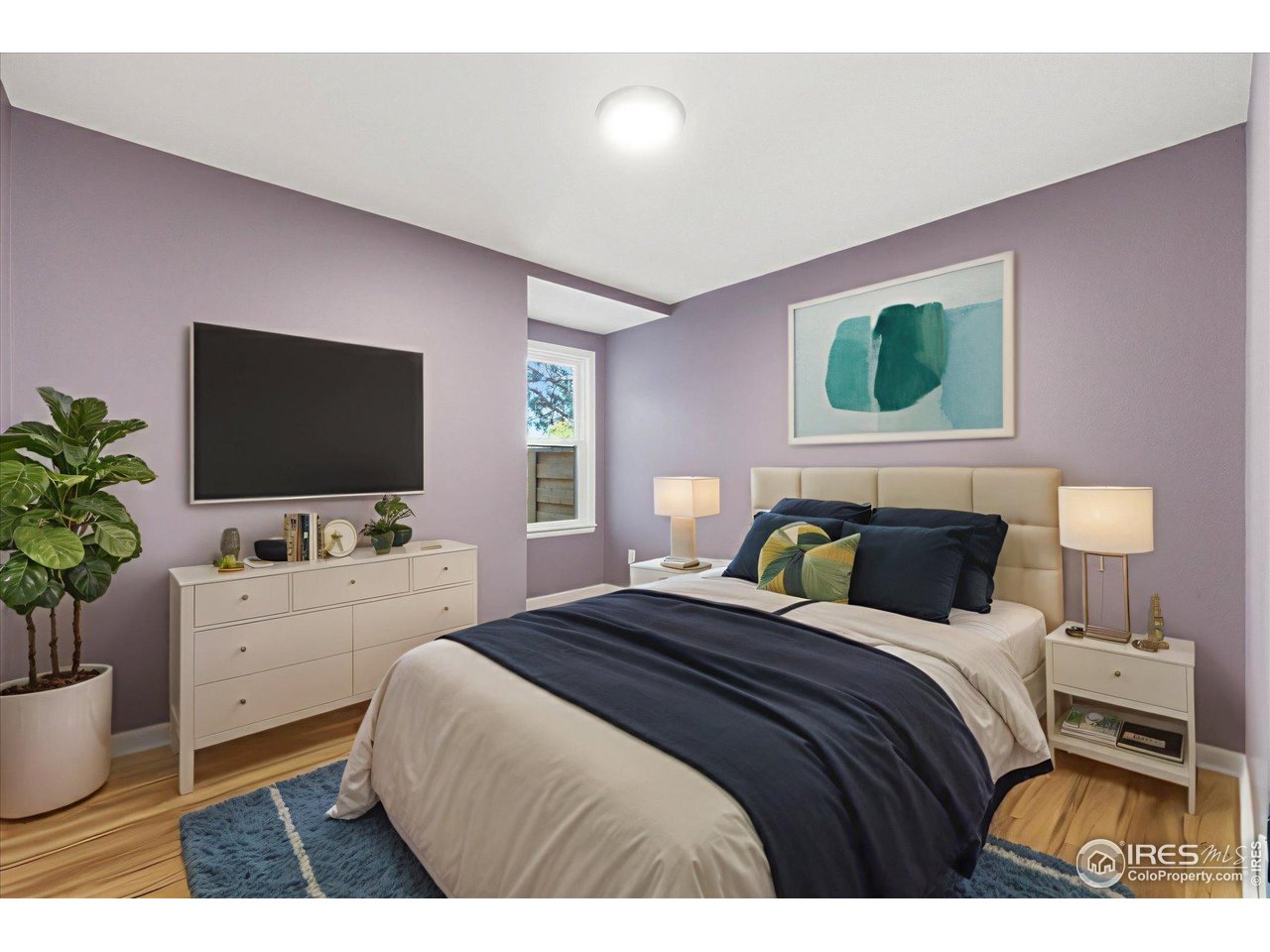 1812 Rice Street Longmont, CO 80501 - Photo 21 of 44 a bedroom with a bed and a flat screen tv