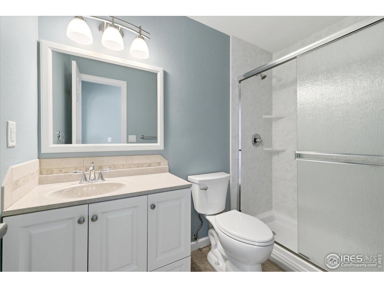 1812 Rice Street Longmont, CO 80501 - Photo 35 of 44 a bathroom with a toilet sink vanity and mirror