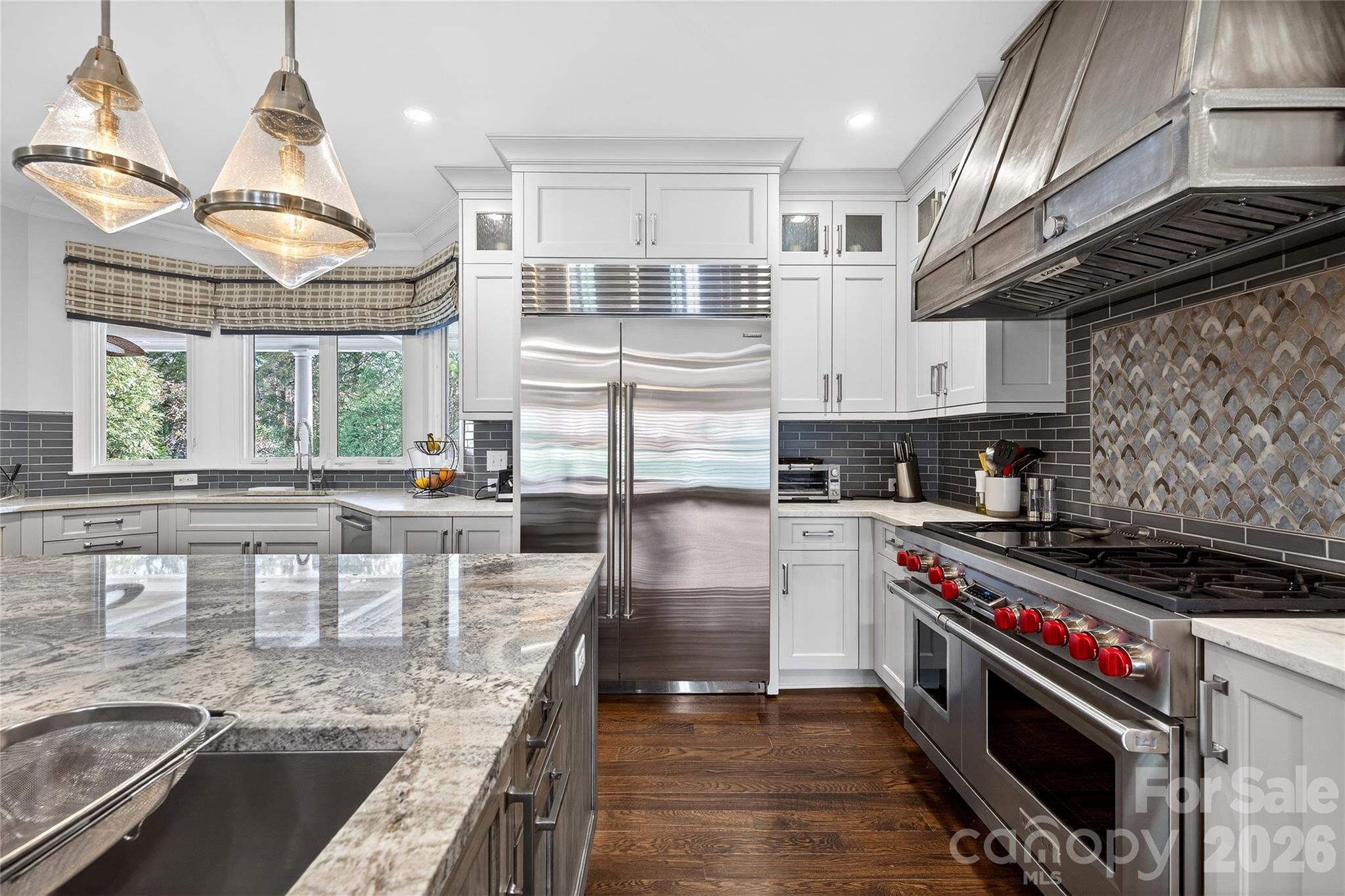 3025 Foxridge Road Charlotte, NC 28226 - Photo 11 of 48 a kitchen with stainless steel appliances granite countertop a stove a sink and a granite counter tops with wooden floors