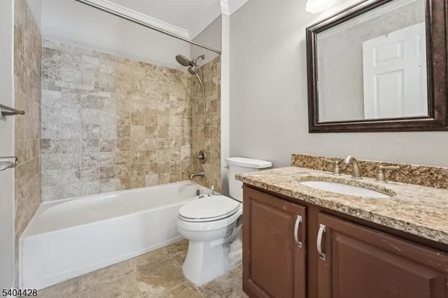 a bathroom with a granite countertop sink toilet mirror and bathtub