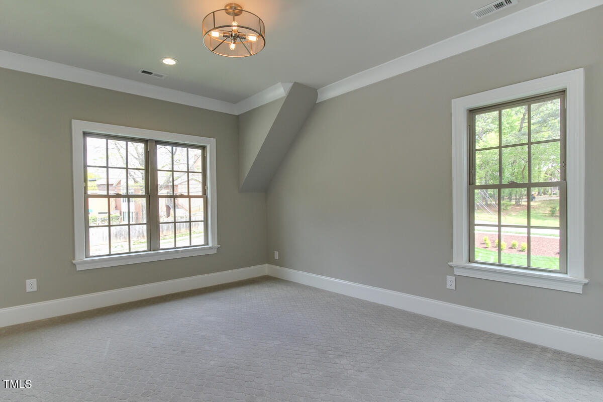 3311 Lake Boone Trail Raleigh, NC 27607 - Photo 20 of 24 an empty room with a chandelier fan and windows