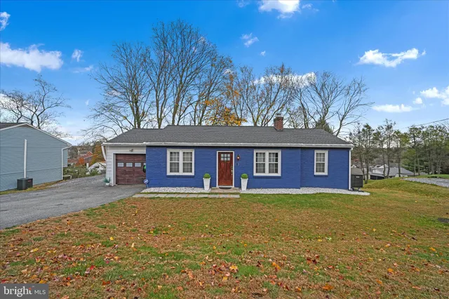 a view of a yard in front of a house with large tree