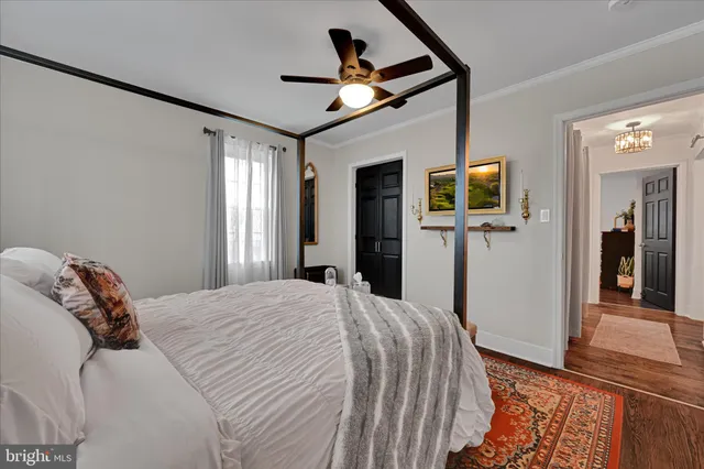 a bedroom with a bed and a flat tv screen on dresser