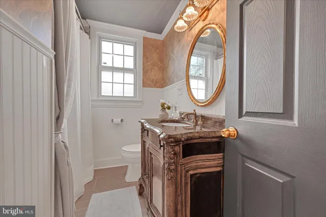 a bathroom with a sink a toilet and a mirror