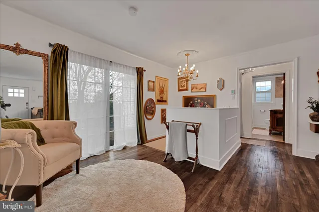 a living room with furniture a large window and wooden floor