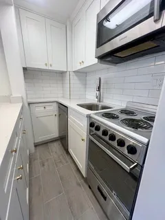 a kitchen with a stove and white cabinets