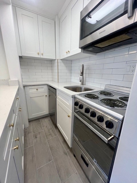 591 Beacon Street, Unit 3 Boston, MA 02215 - Photo 3 of 10 a kitchen with a stove and white cabinets