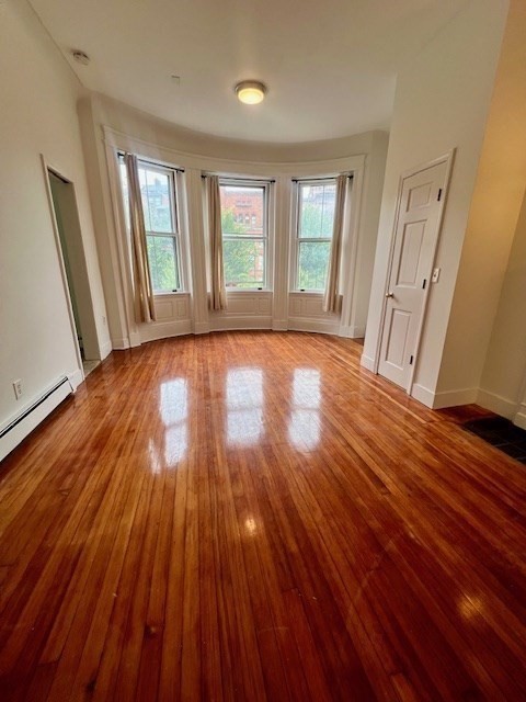 591 Beacon Street, Unit 3 Boston, MA 02215 - Photo 7 of 10 wooden floor in an empty room with a window