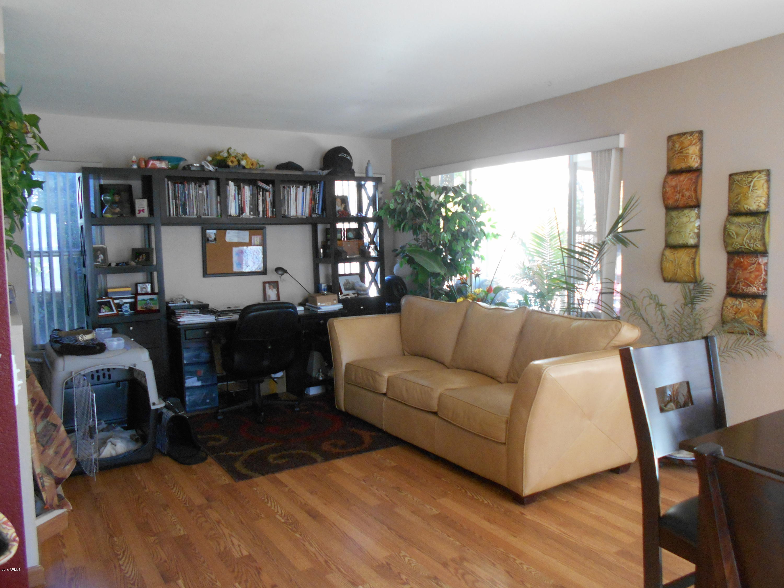 4902 West Tonto Road Glendale, AZ 85308 - Photo 5 of 22 a living room with furniture a lamp and a floor to ceiling window