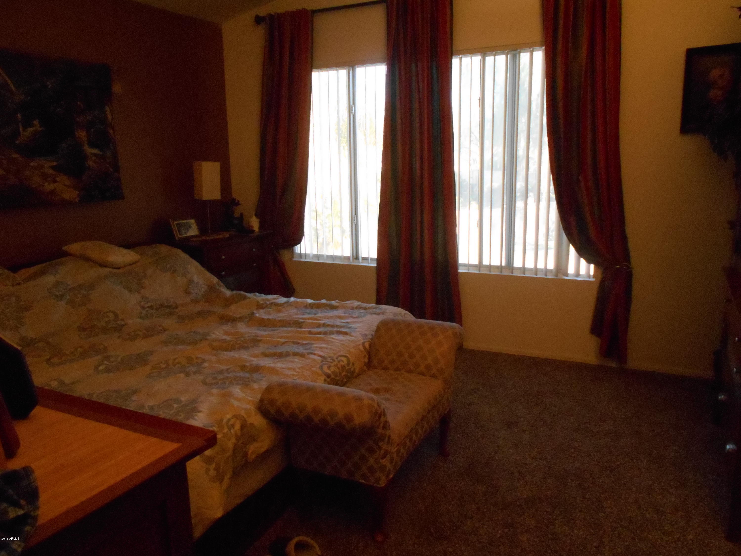 4902 West Tonto Road Glendale, AZ 85308 - Photo 7 of 22 a bed sitting in a bedroom next to a window
