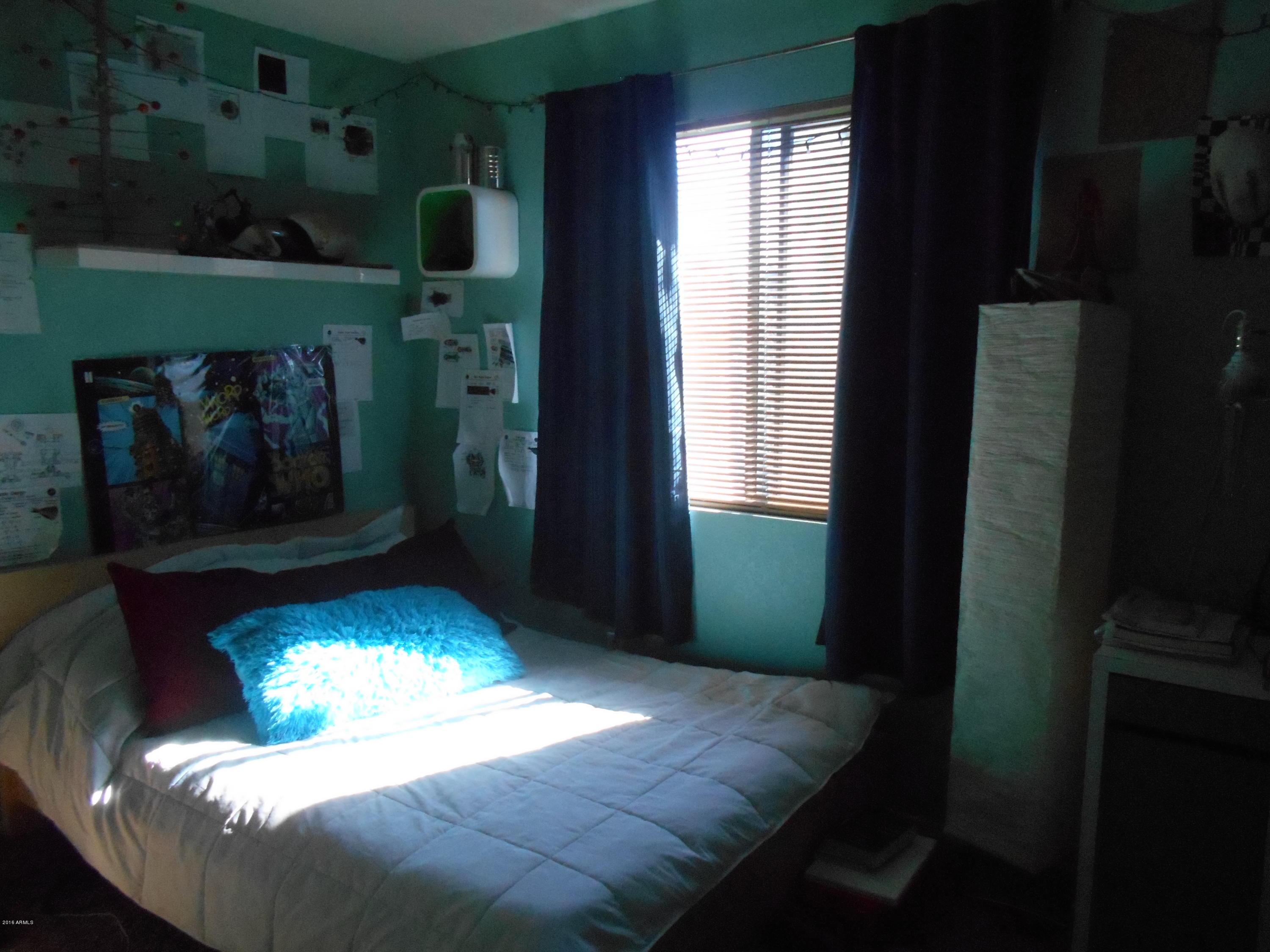 4902 West Tonto Road Glendale, AZ 85308 - Photo 10 of 22 a bedroom with a bed and a fireplace