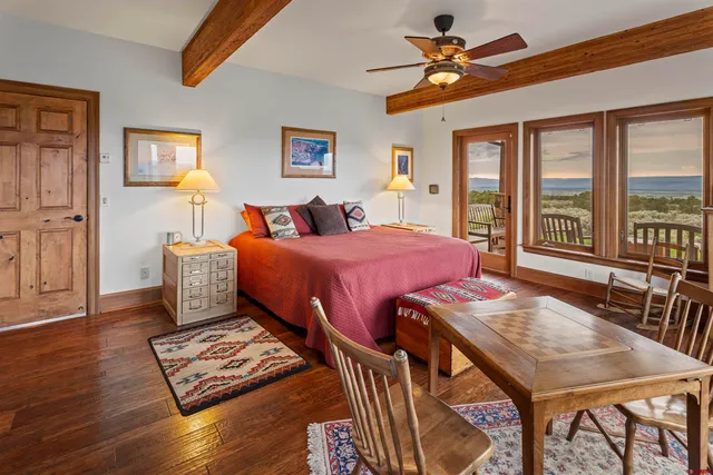 a bedroom with a bed a table and chair with the outer view