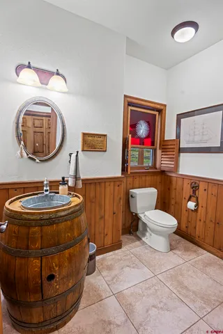 a room with a mirror and painting on the wall