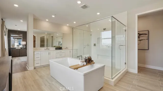a bathroom with a bathtub shower sink double and mirror